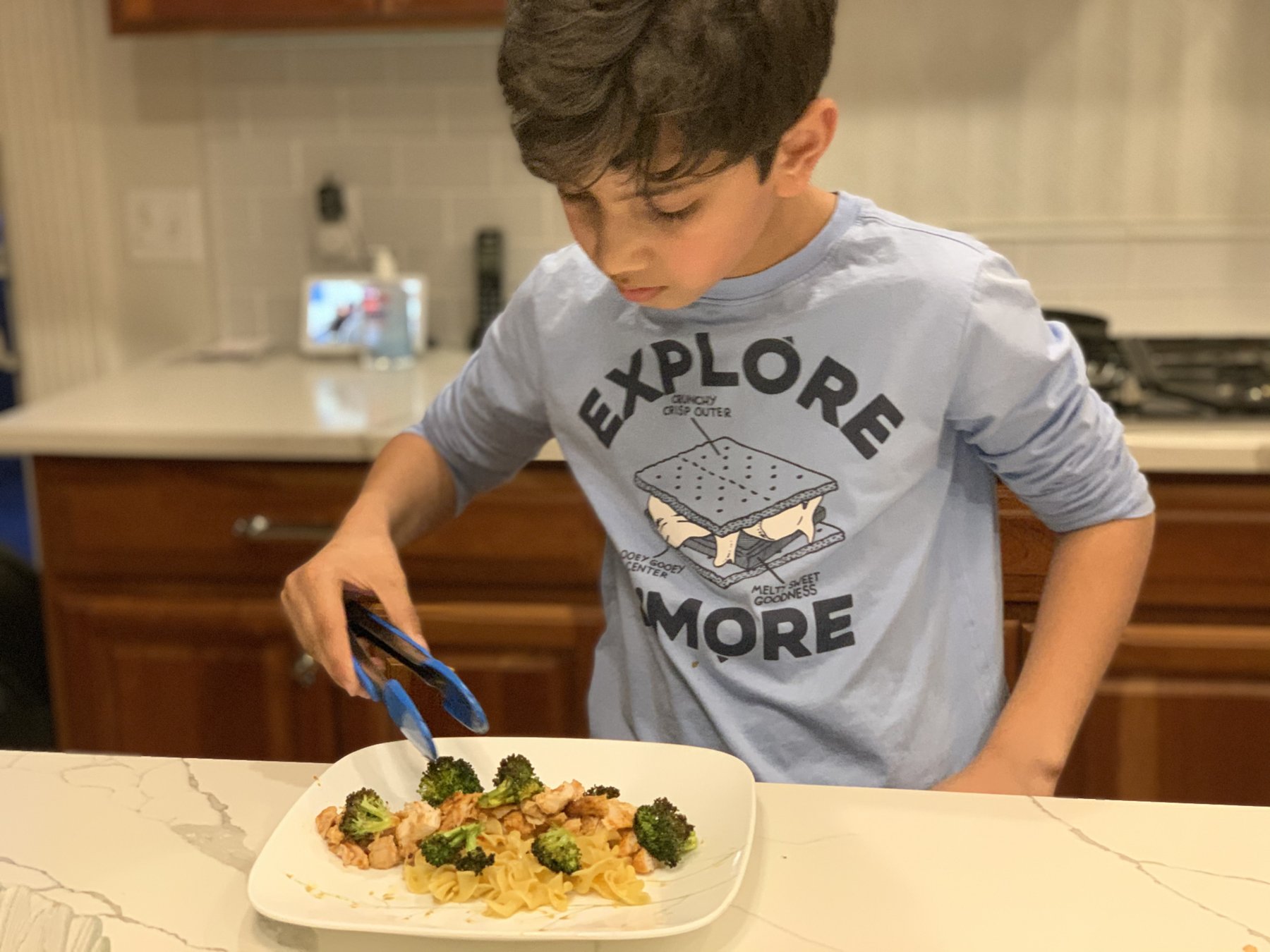 Plating a chicken, broccoli, and noodle dish I cooked